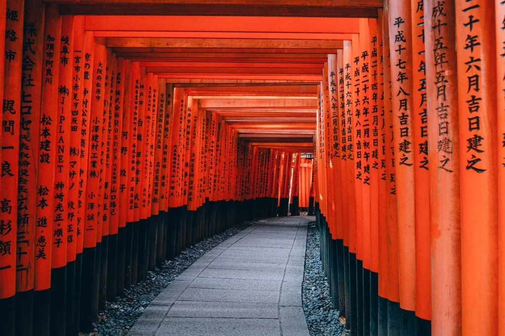 Image depicting the iconic red torii gates ascending the mountain at Fushimi Inari-taisha, with Mount Inariyama in the background