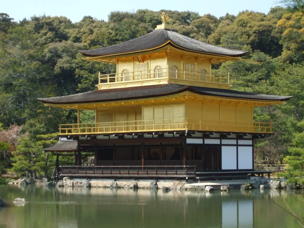 The Kinkaku-ji Temple, also known as the Golden Pavilion, sits resplendent on a pond in Kyoto, its golden walls shimmering in the sunlight.